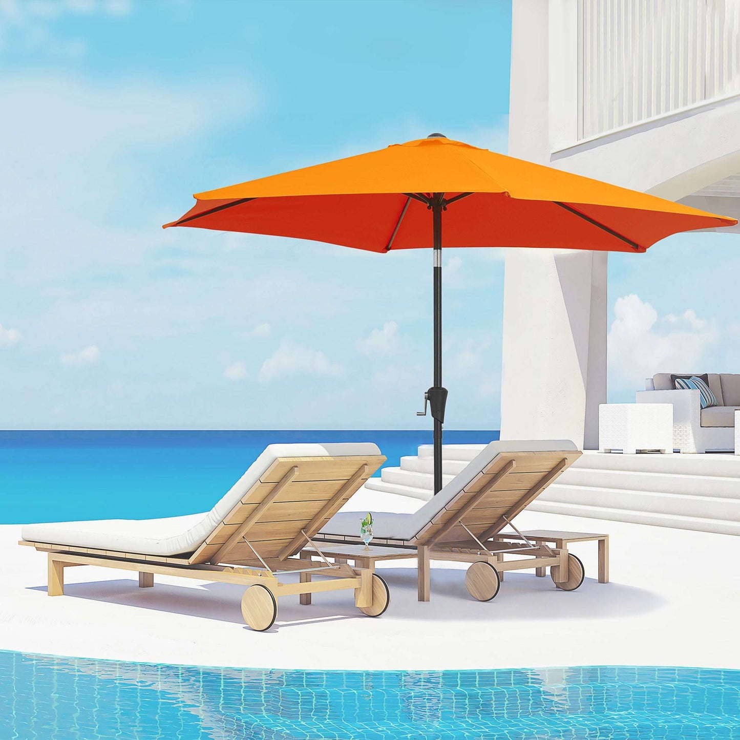 Orange umbrella and lounge chairs by a pool with a blue sky background