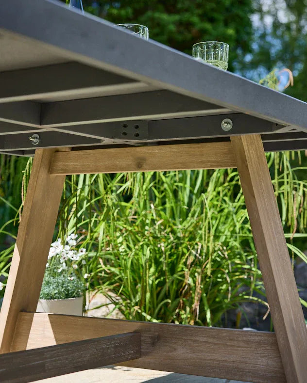 Close-up of a underneath grey outdoor table with wooden legs