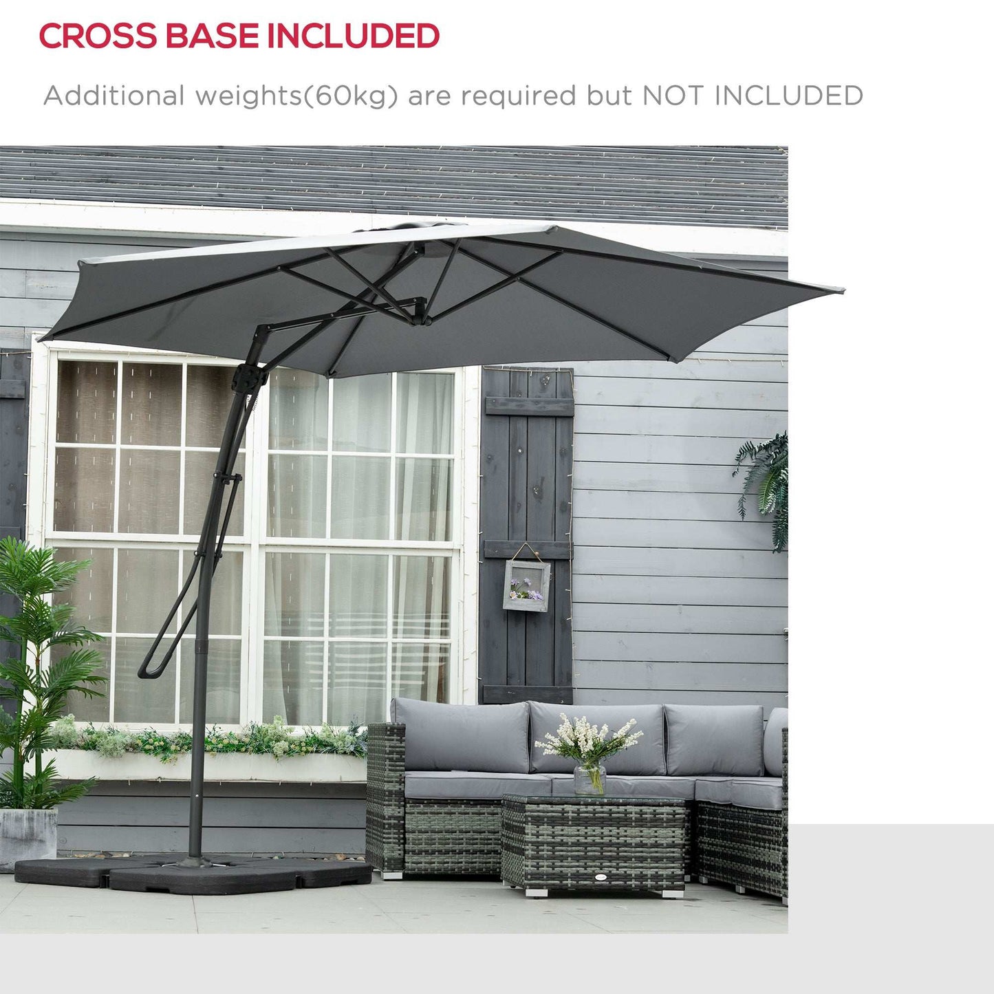 Grey patio umbrella with cross base on a patio with a couch and table.