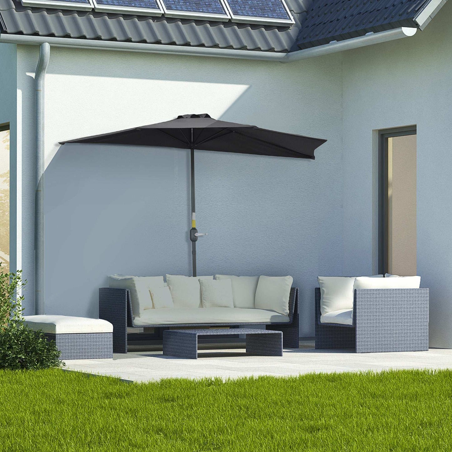 Outdoor patio set with a large umbrella on a patio area in front of a house.