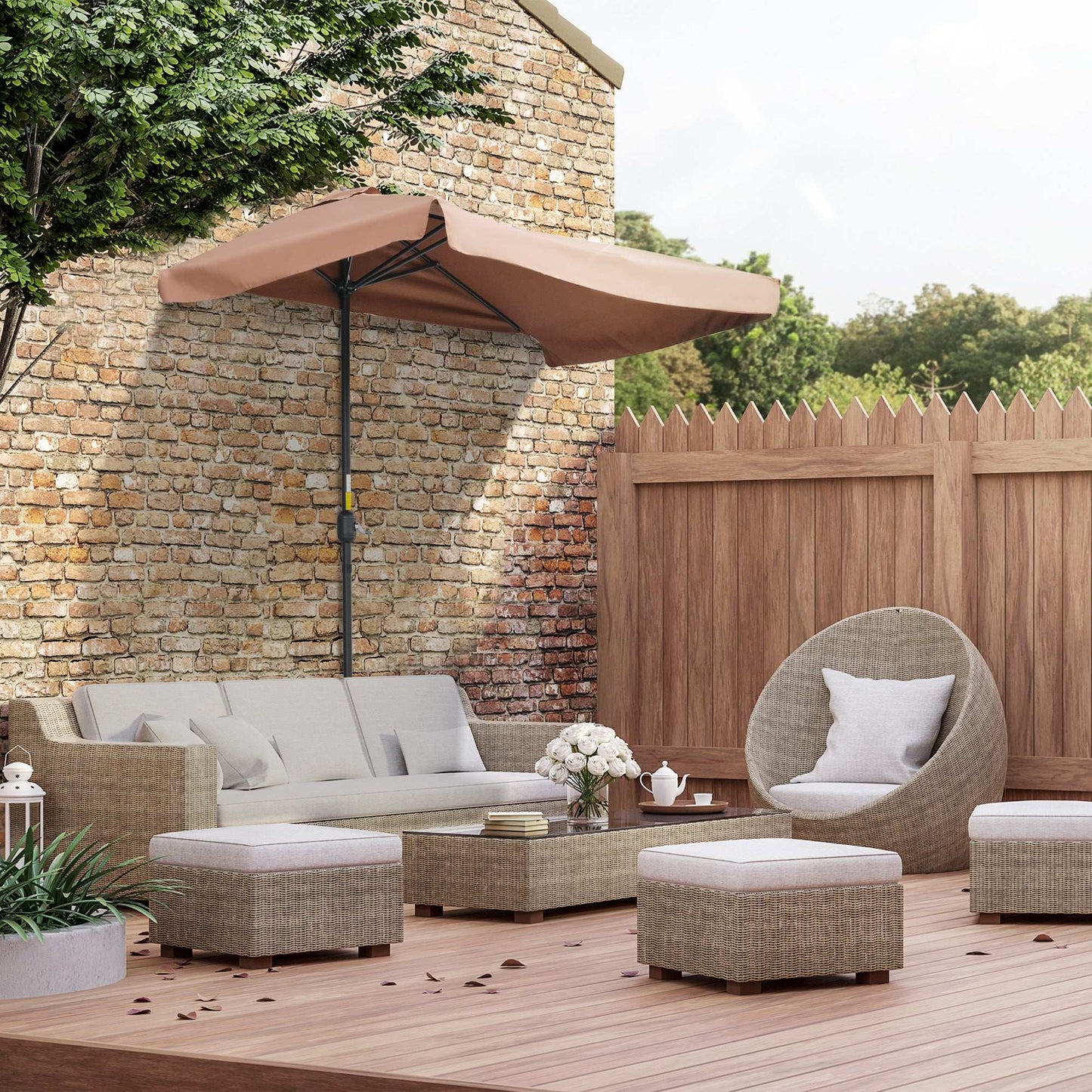 Outdoor patio set with furniture and umbrella against a stone wall.