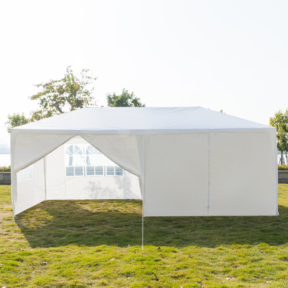White outdoor canopy tent with side walls on a grassy area