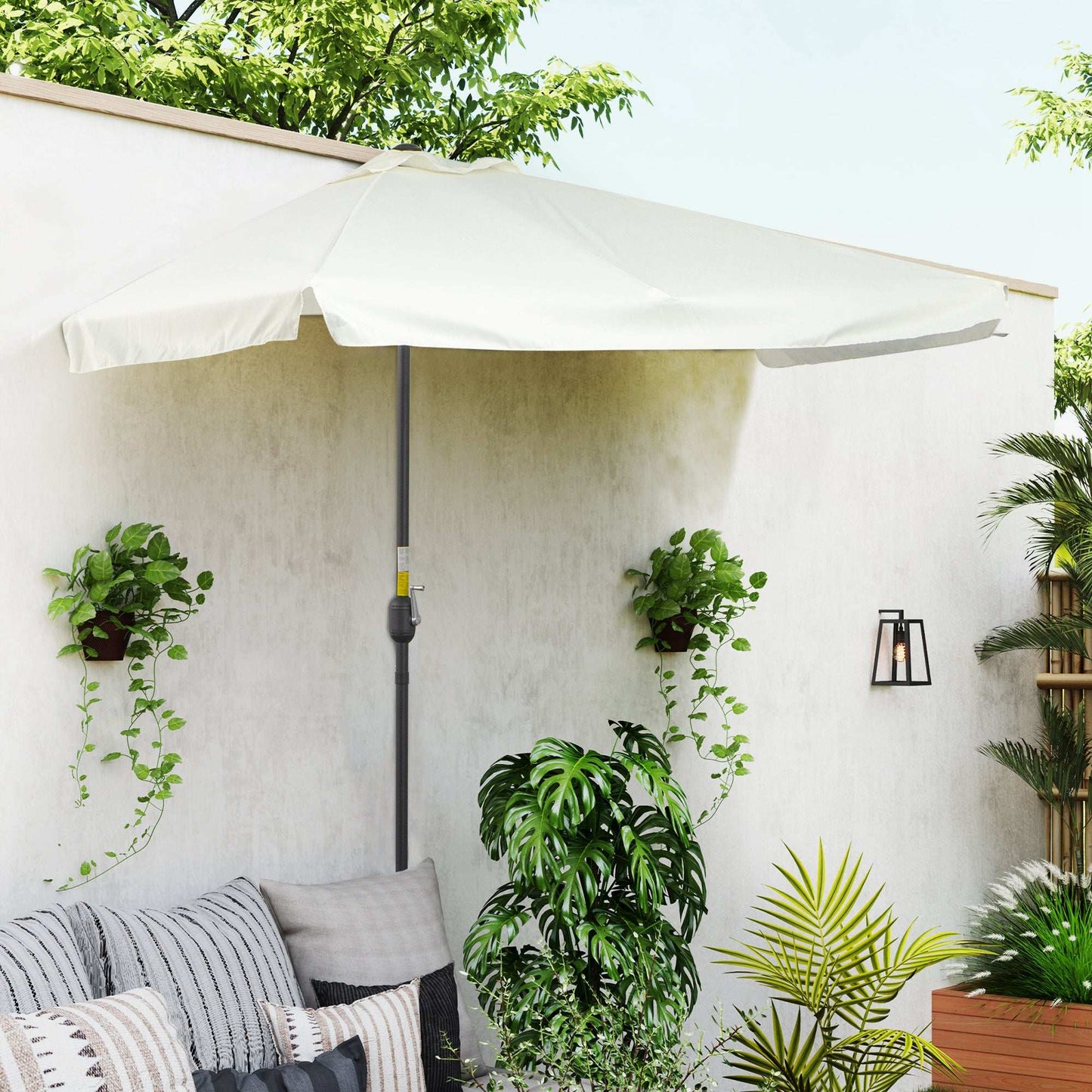 Outdoor patio with a white umbrella, plants, and a wall-mounted light fixture.