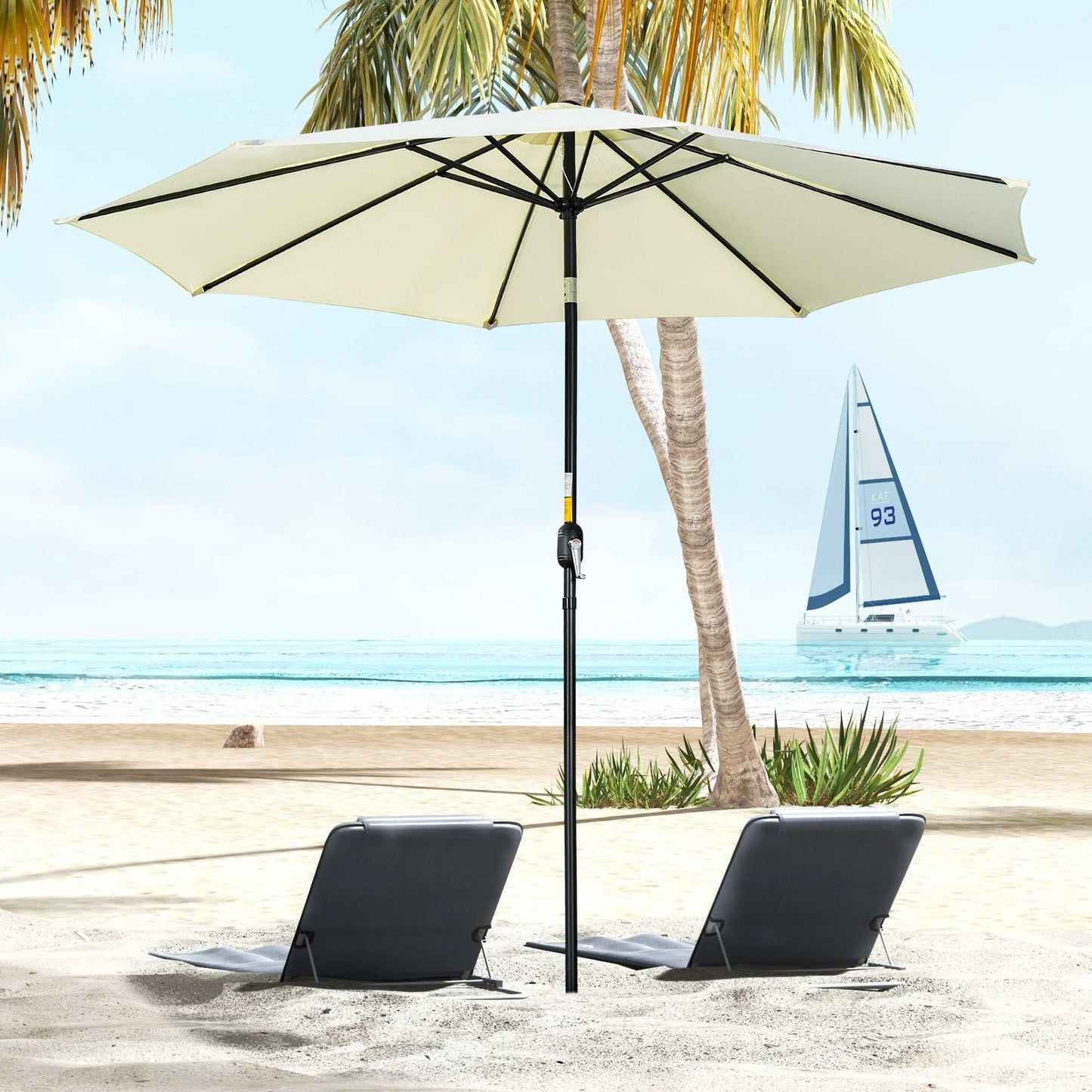 Beige patio umbrella on a beach with lounge chairs and palm trees in the background