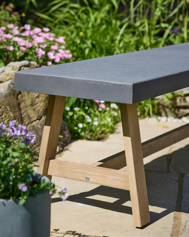 Bench with a grey seat and wooden legs.