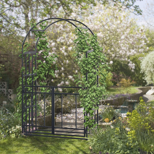 Black metal garden archway with climbing plants in a garden setting