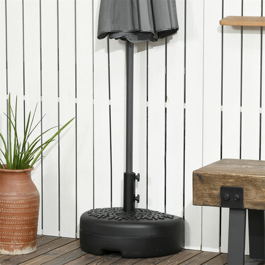 Black outdoor umbrella stand on a wooden deck with a plant and small table.