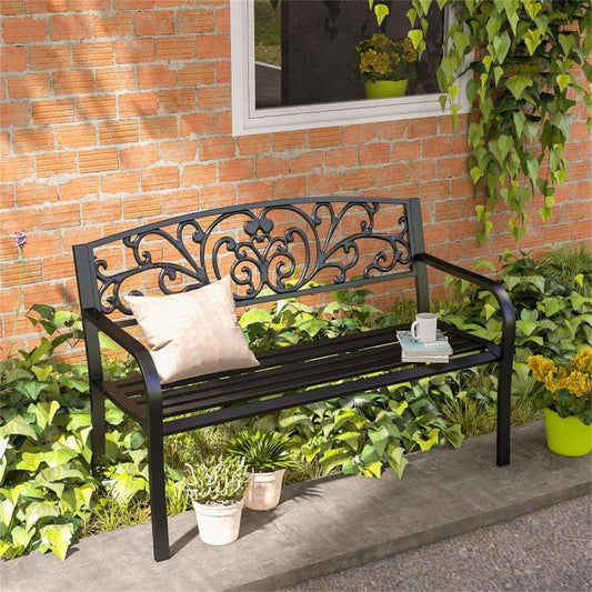 Decorative garden bench with ornate metalwork in a garden setting.