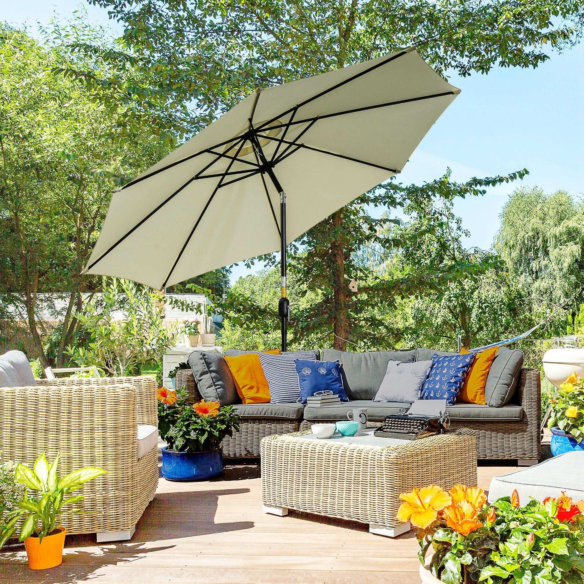 Outdoor patio setting with a large umbrella, couch, and decorative plants on a wooden deck.