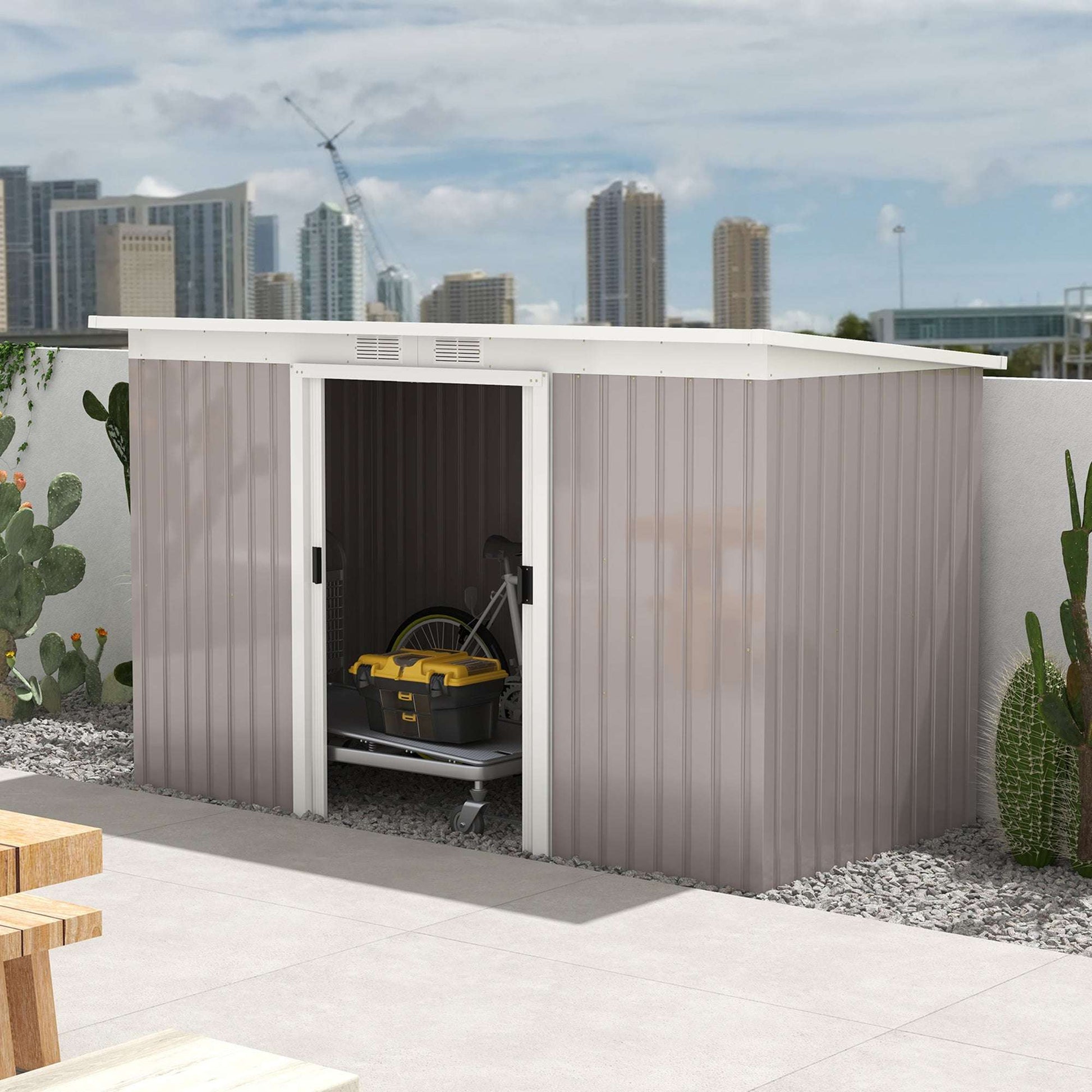 Garden shed with sliding doors open to reveal storage inside, set against a rooftop terrace with city buildings in background.