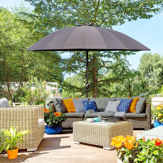 Outdoor patio with wicker furniture, cushions, and a large umbrella on a sunny day.