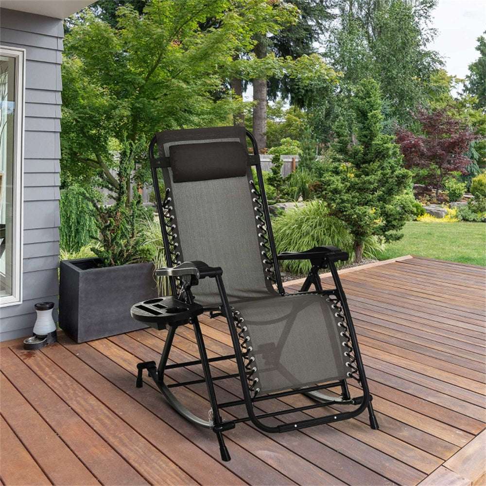 Grey reclining chair on a wooden deck with greenery in the background
