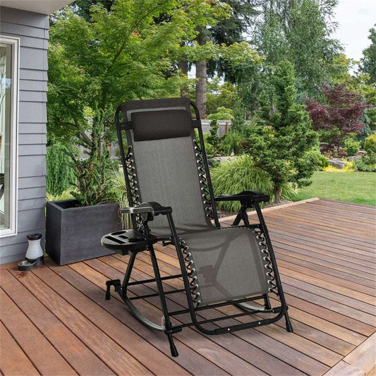 Grey reclining chair on a wooden deck with greenery in the background