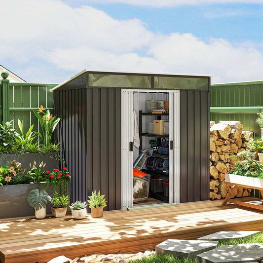 Modern garden shed with white double doors on raised wooden deck, surrounded by lush planters and firewood.