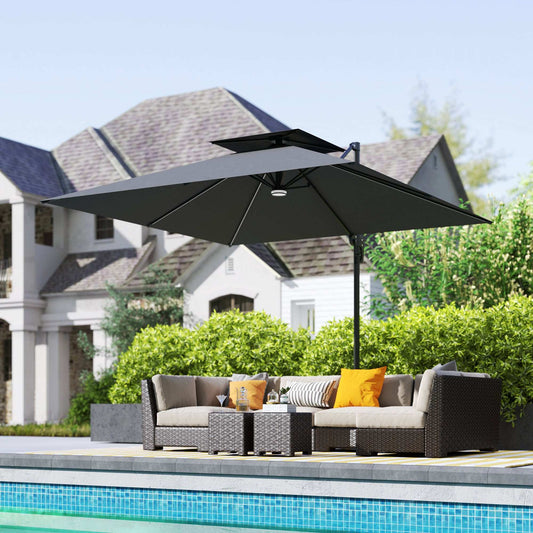 Outdoor patio set with a large black umbrella by a poolside.