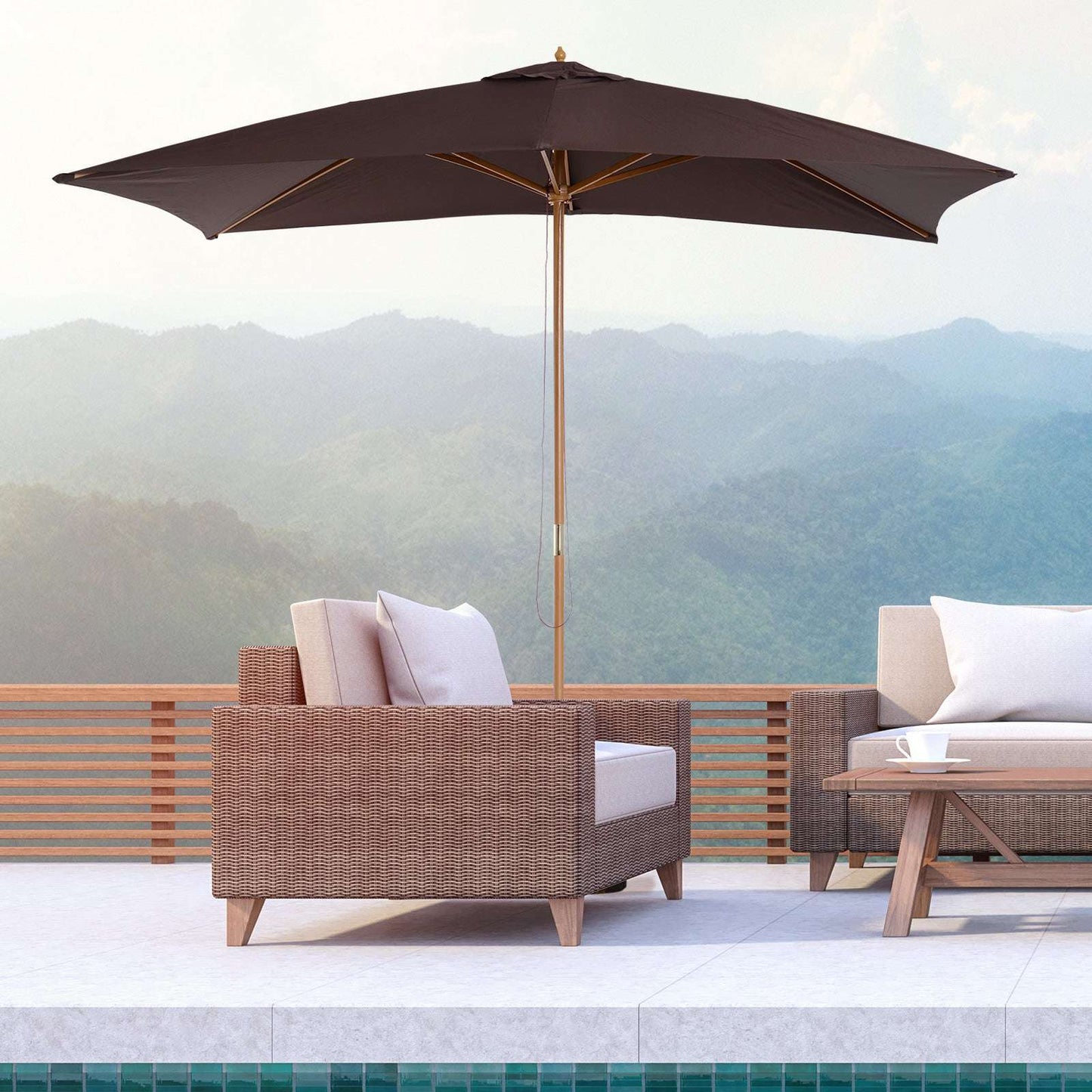 Outdoor patio furniture set with a large umbrella overlooking mountains.