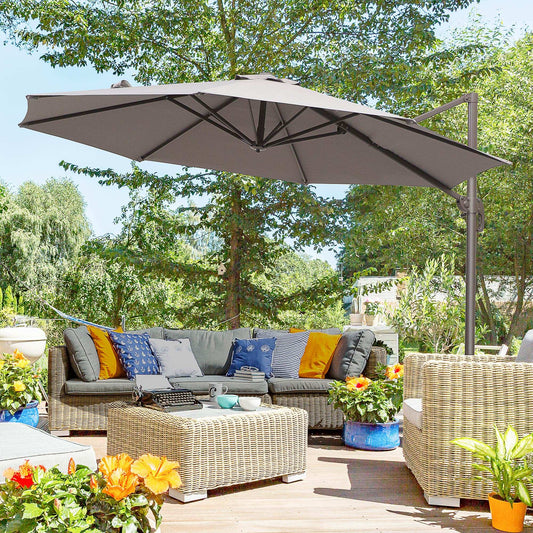 Outdoor patio set with a large umbrella, couch, and coffee table in a garden setting.