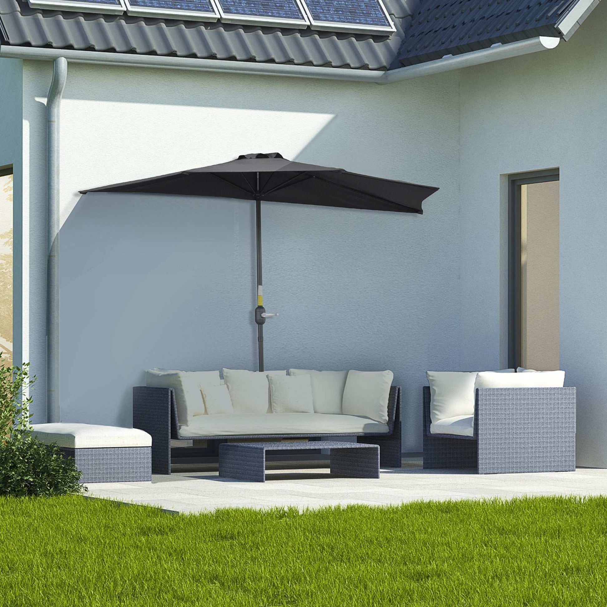Outdoor patio set with a large umbrella on a patio area in front of a house.