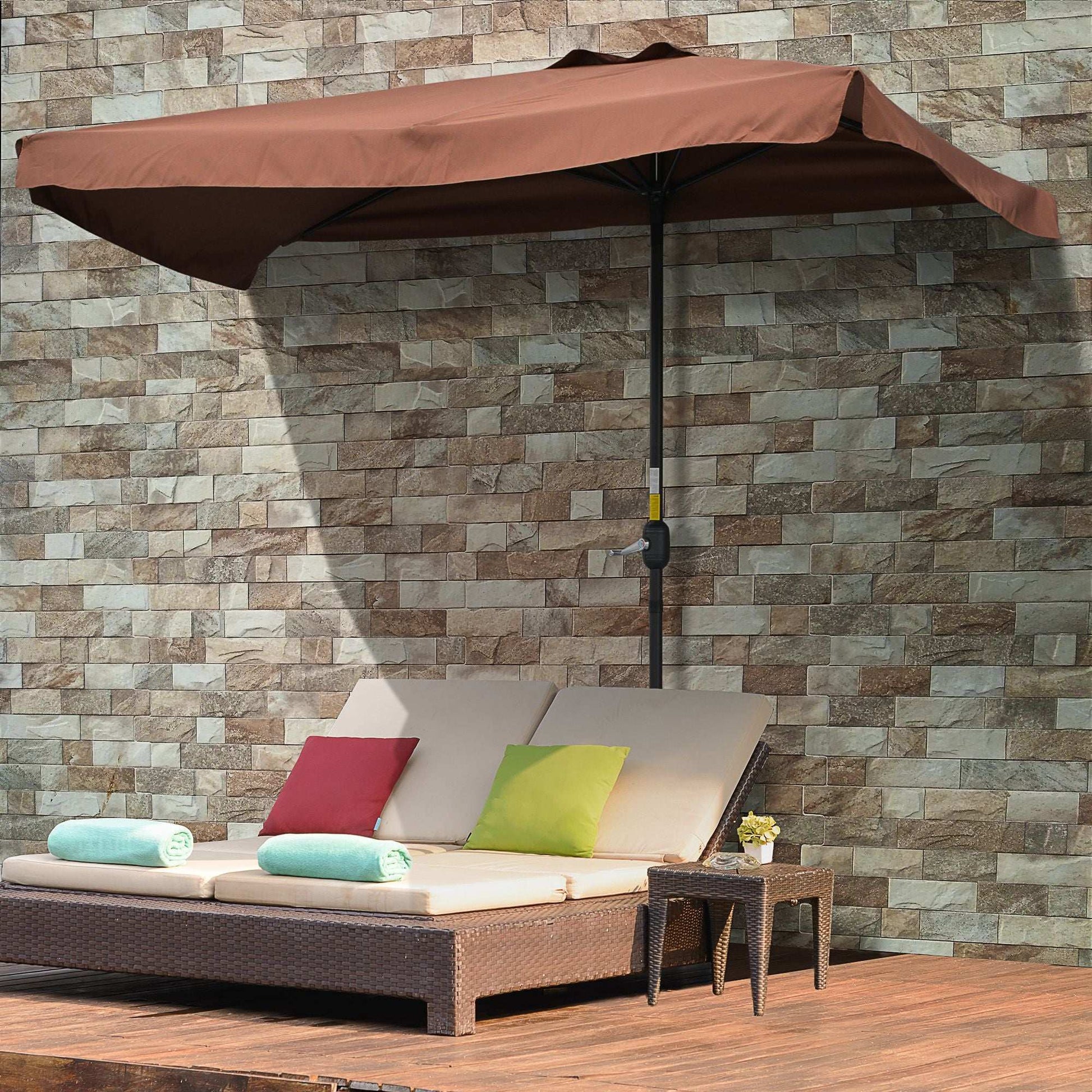Outdoor patio set with cushions and umbrella against a stone wall.