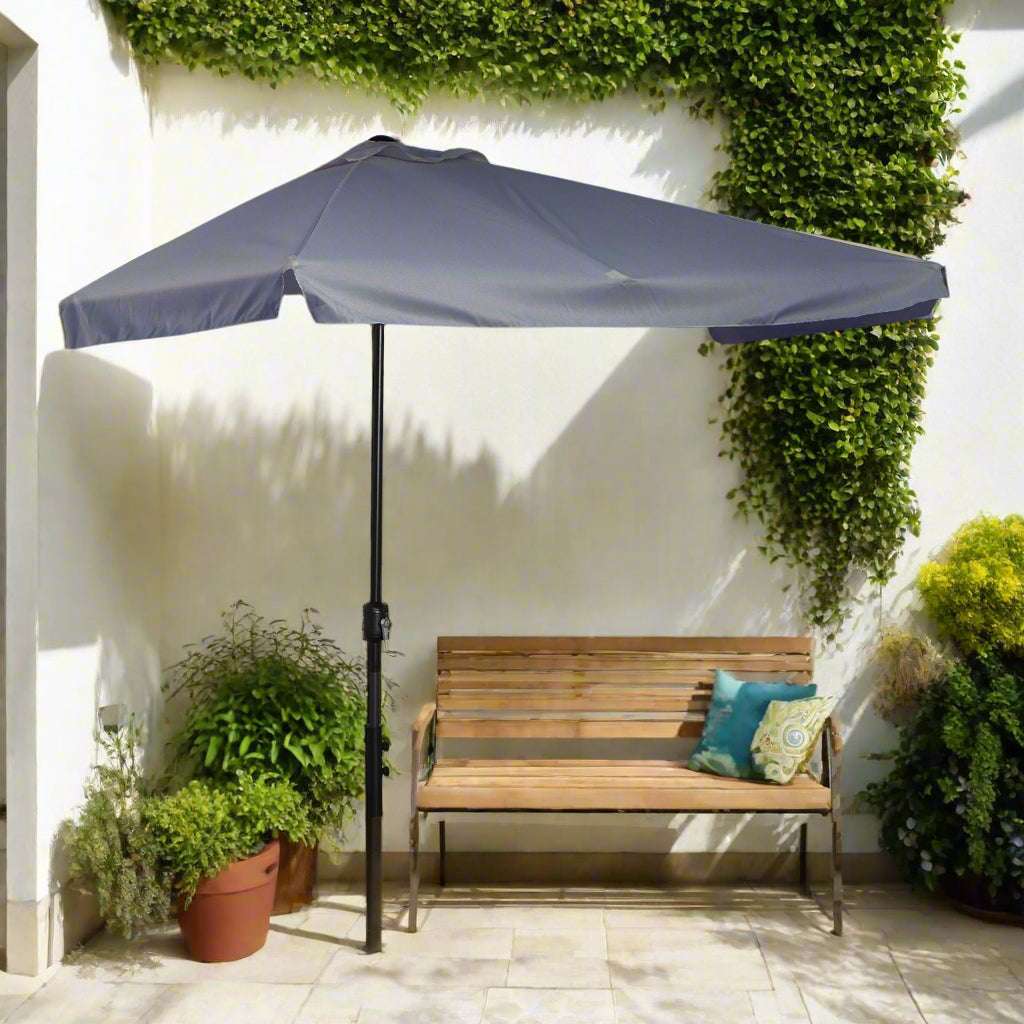 Outdoor patio with a large blue umbrella, plants, and a wall light fixture.