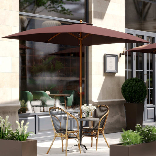 Outdoor patio with umbrella, table, chairs, and plants in an urban setting.