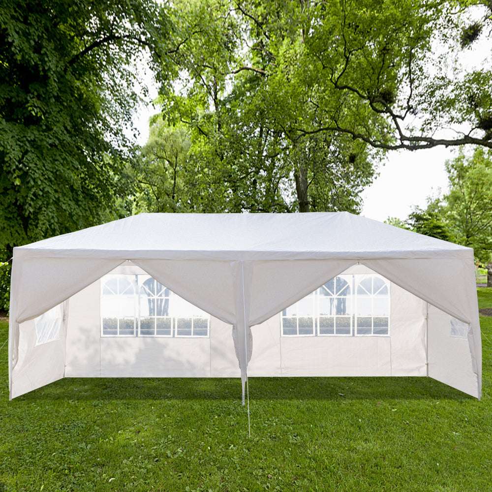 White outdoor canopy tent with side walls on a grassy area with trees in the background