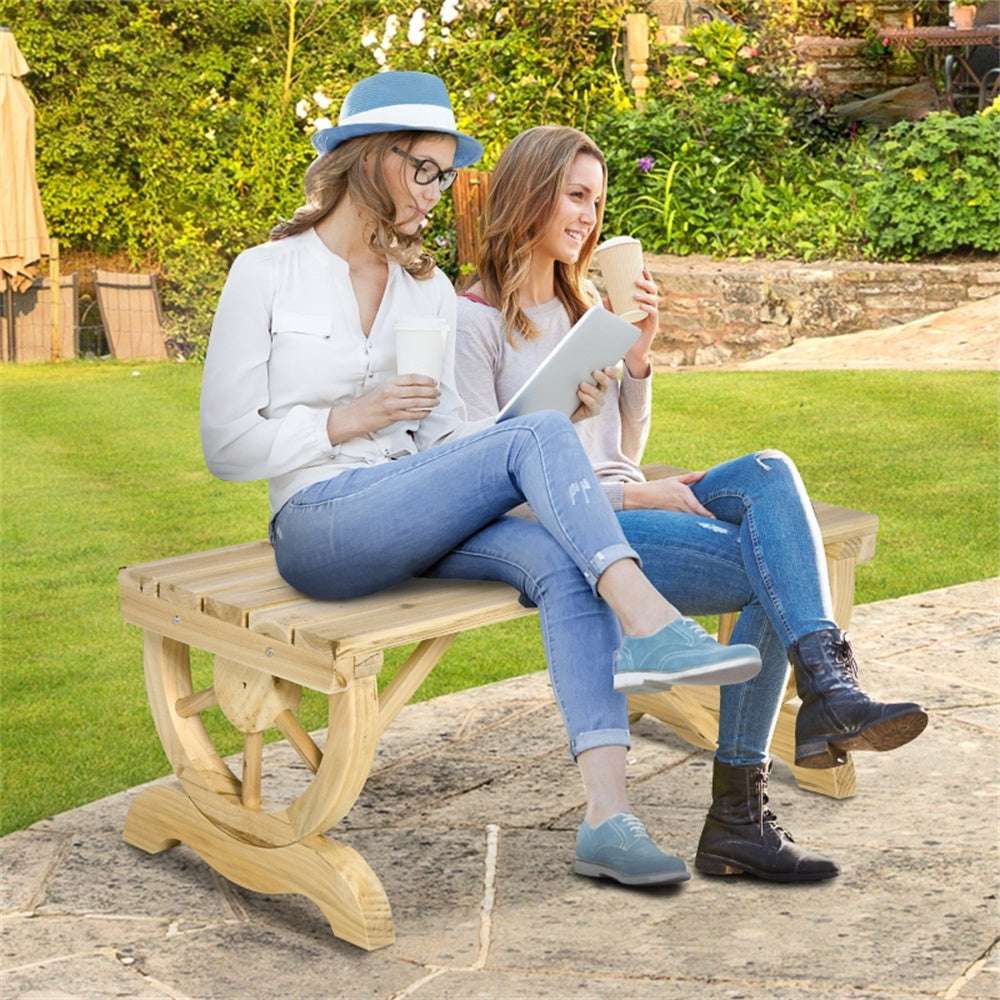 Two women sitting on a wooden bench in a garden, one using a tablet.