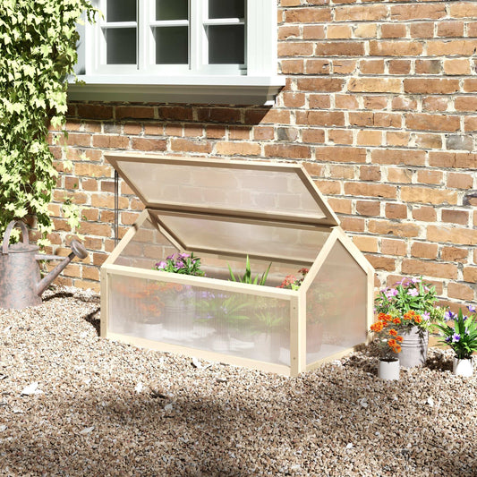 Wooden cold frame with plants against a brick wall