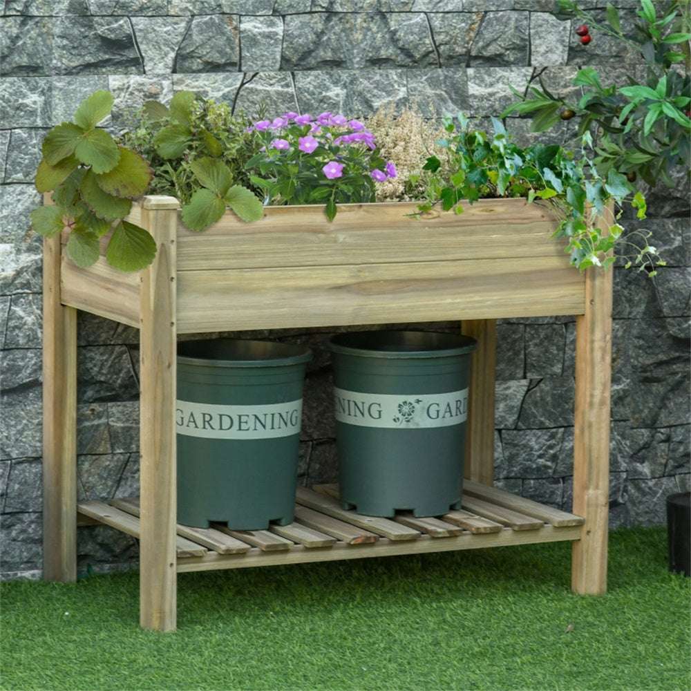 Wooden garden bench with planters and flowers against a stone wall.