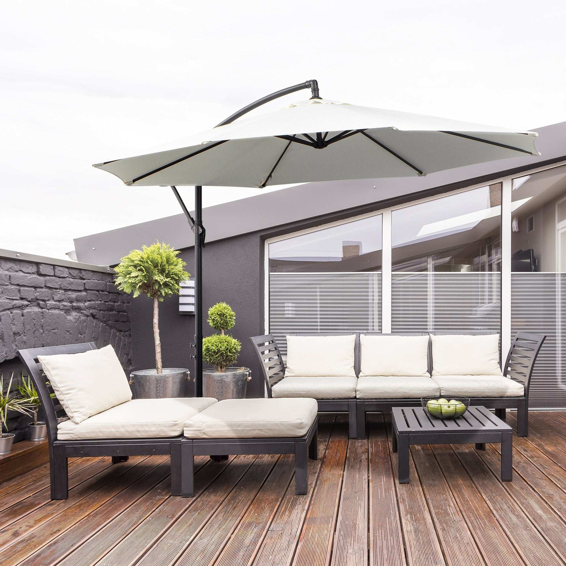 Outdoor patio set with cushions, umbrella, and small table on a wooden deck.