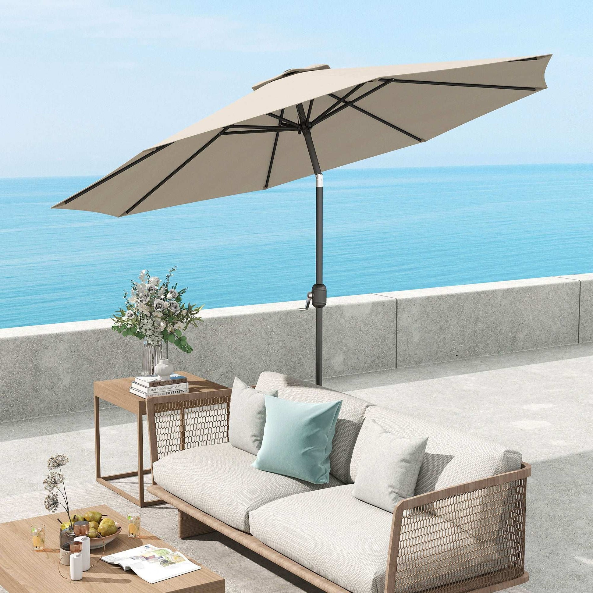 Beige patio umbrella over an outdoor sofa set with a view of the ocean.